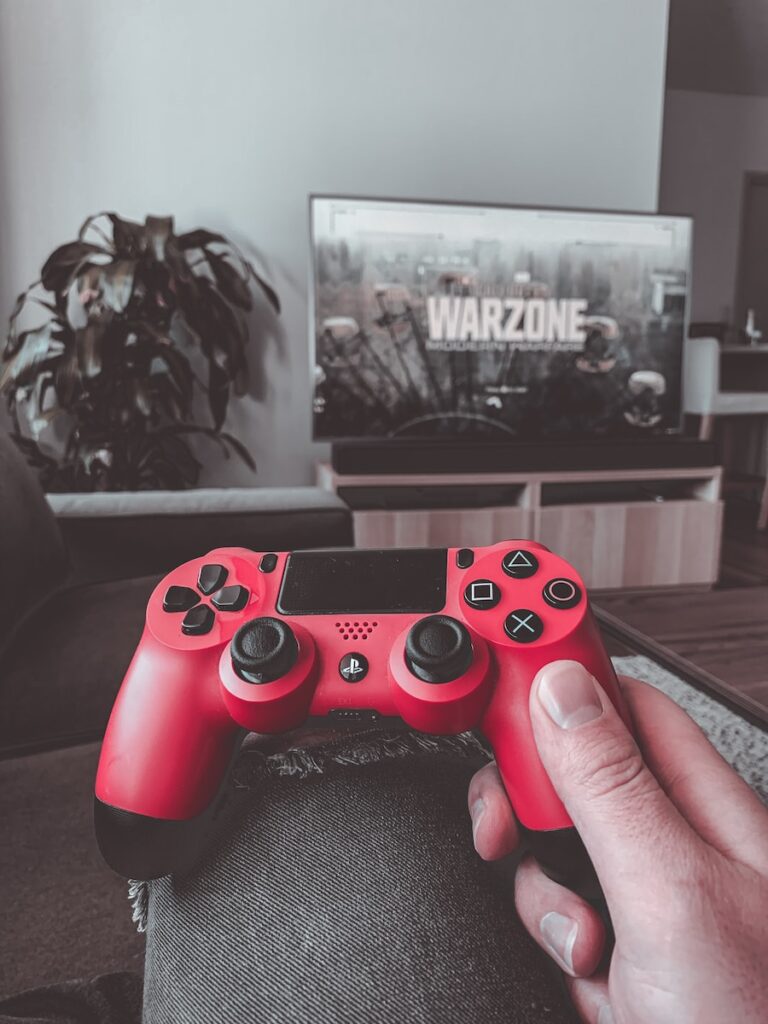 person holding red sony ps 4 controller